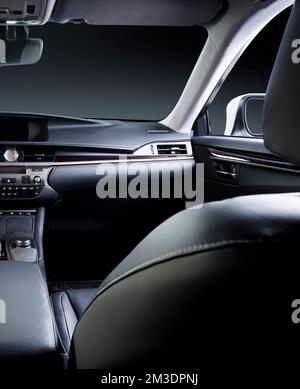 Dunkler Luxus-Innenraum – Lenkrad, Schalthebel und Armaturenbrett. Das Auto ist drin. Beige bequeme Sitze, Lenkrad, Armaturenbrett, Klimaregelung, Stockfoto