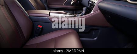 Moderner, luxuriöser Rennwagen in Schwarz und Rot mit perforiertem Leder-Interieur. Ein Teil der Ledersitze. Stockfoto