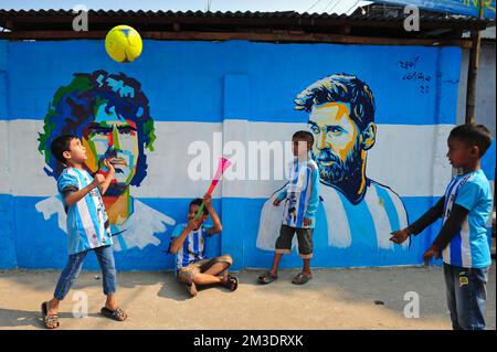 Nicht exklusiv: 14. Dezember 2022 in Sylhet, Bangladesch: Junge argentinische Fans, die feiern, posieren vor einem Wandbild seines Helden Lionel Messi und gewinnen Cro Stockfoto