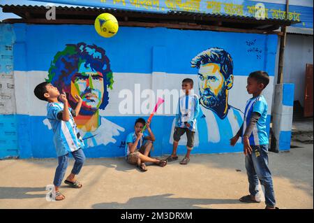 Nicht exklusiv: 14. Dezember 2022 in Sylhet, Bangladesch: Junge argentinische Fans, die feiern, posieren vor einem Wandbild seines Helden Lionel Messi und gewinnen Cro Stockfoto