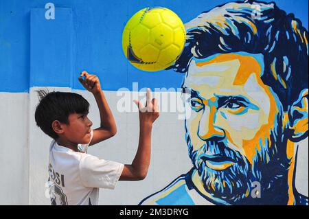 Nicht exklusiv: 14. Dezember 2022 in Sylhet, Bangladesch: Junge argentinische Fans, die feiern, posieren vor einem Wandbild seines Helden Lionel Messi und gewinnen Cro Stockfoto