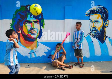 Nicht exklusiv: 14. Dezember 2022 in Sylhet, Bangladesch: Junge argentinische Fans, die feiern, posieren vor einem Wandbild seines Helden Lionel Messi und gewinnen Cro Stockfoto