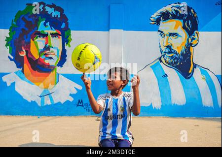 Nicht exklusiv: 14. Dezember 2022 in Sylhet, Bangladesch: Junge argentinische Fans, die feiern, posieren vor einem Wandbild seines Helden Lionel Messi und gewinnen Cro Stockfoto