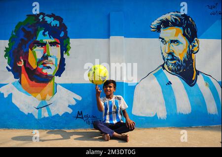 Nicht exklusiv: 14. Dezember 2022 in Sylhet, Bangladesch: Junge argentinische Fans, die feiern, posieren vor einem Wandbild seines Helden Lionel Messi und gewinnen Cro Stockfoto