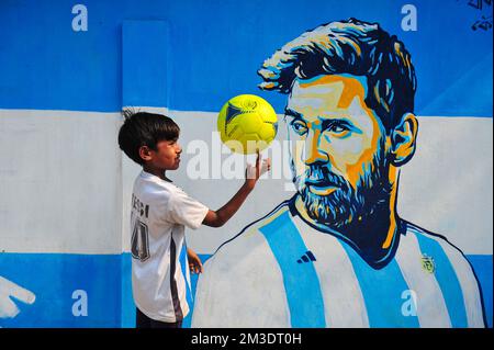 Nicht exklusiv: 14. Dezember 2022 in Sylhet, Bangladesch: Junge argentinische Fans, die feiern, posieren vor einem Wandbild seines Helden Lionel Messi und gewinnen Cro Stockfoto