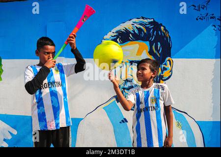 Nicht exklusiv: 14. Dezember 2022 in Sylhet, Bangladesch: Junge argentinische Fans, die feiern, posieren vor einem Wandbild seines Helden Lionel Messi und gewinnen Cro Stockfoto