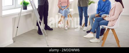 Junger Mann, der während der Besprechung des Geschäftsteams vor dem Whiteboard eine Präsentation hält Stockfoto