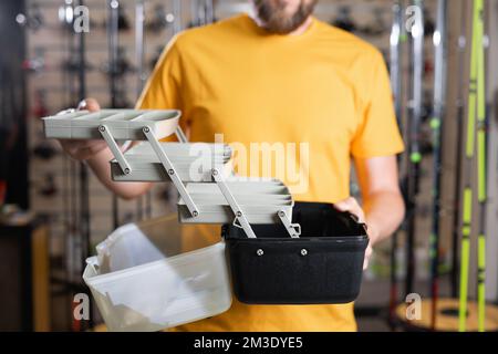 Ein Mann, der Angelausrüstung im Laden hat, ein Fischer, der Zubehör aussucht Stockfoto