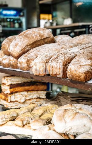 Brotlaibe auf den Regalen der Bäckerei. Frisches, hausgemachtes Weizen, Vollkornbrot und Gebäck. Hochwertiges Foto Stockfoto