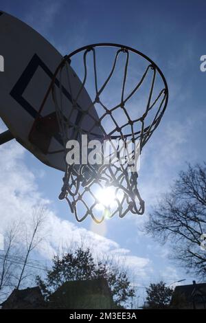Basketballkorb von unten gegen die Sonne gesehen Stockfoto