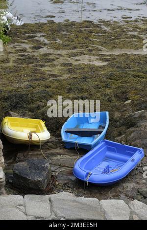 Kleine Fischerboote, die bei Ebbe im Hafen vor Anker liegen Stockfoto