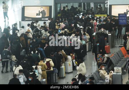 HANGZHOU, CHINA - 15. DEZEMBER 2022 - Eine große Anzahl von Passagieren mit Masken wartet in der Warterhalle des Ostbahnhofs Hangzhou in Hangzhou Stockfoto