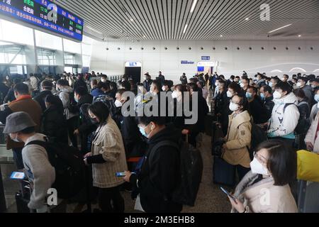 HANGZHOU, CHINA - 15. DEZEMBER 2022 - Eine große Anzahl von Passagieren mit Masken wartet in der Warterhalle des Ostbahnhofs Hangzhou in Hangzhou Stockfoto