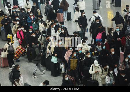 HANGZHOU, CHINA - 15. DEZEMBER 2022 - Eine große Anzahl von Passagieren mit Masken wartet in der Warterhalle des Ostbahnhofs Hangzhou in Hangzhou Stockfoto