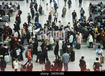 HANGZHOU, CHINA - 15. DEZEMBER 2022 - Eine große Anzahl von Passagieren mit Masken wartet in der Warterhalle des Ostbahnhofs Hangzhou in Hangzhou Stockfoto