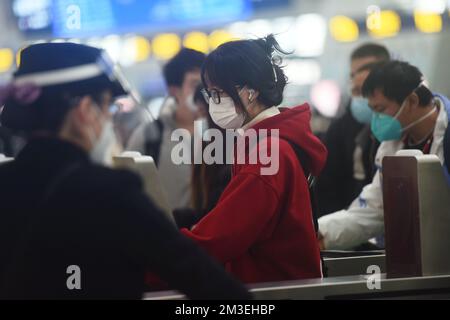 HANGZHOU, CHINA - 15. DEZEMBER 2022 - Eine große Anzahl von Passagieren mit Masken passieren die automatische Ticketbarriere in der Warthalle von Hang Stockfoto