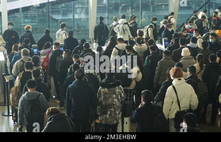 HANGZHOU, CHINA - 15. DEZEMBER 2022 - Eine große Anzahl von Passagieren mit Masken wartet in der Warterhalle des Ostbahnhofs Hangzhou in Hangzhou Stockfoto