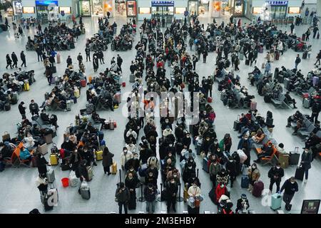 HANGZHOU, CHINA - 15. DEZEMBER 2022 - Eine große Anzahl von Passagieren mit Masken wartet in der Warterhalle des Ostbahnhofs Hangzhou in Hangzhou Stockfoto