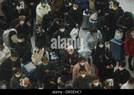 HANGZHOU, CHINA - 15. DEZEMBER 2022 - Eine große Anzahl von Passagieren mit Masken wartet in der Warterhalle des Ostbahnhofs Hangzhou in Hangzhou Stockfoto