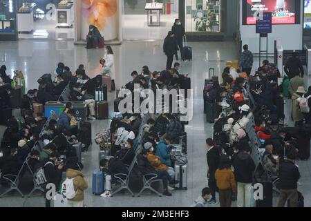 HANGZHOU, CHINA - 15. DEZEMBER 2022 - Eine große Anzahl von Passagieren mit Masken wartet in der Warterhalle des Ostbahnhofs Hangzhou in Hangzhou Stockfoto