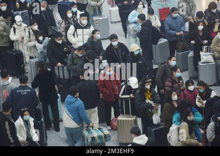 HANGZHOU, CHINA - 15. DEZEMBER 2022 - Eine große Anzahl von Passagieren mit Masken wartet in der Warterhalle des Ostbahnhofs Hangzhou in Hangzhou Stockfoto