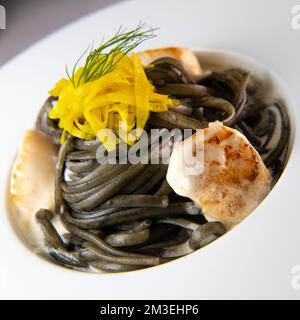 Rezept für Linguine Pasta mit Tintenfischtinte und Jakobsmuscheln, gelbe chioggia-Beete Stockfoto