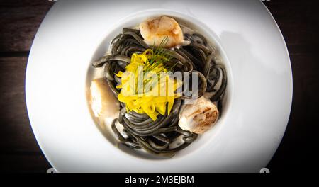 Rezept für Linguine Pasta mit Tintenfischtinte und Jakobsmuscheln, gelbe chioggia-Beete Stockfoto