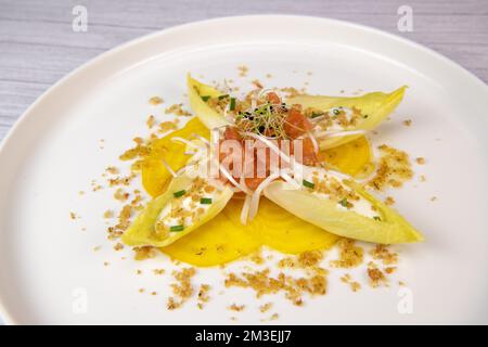 Rezept für Lachs-Gravlax-Salat, Endivien mit frischer Sahne, Schnittlauch, gelbe chioggia-Rote Beete und Lauch-Triebe Stockfoto