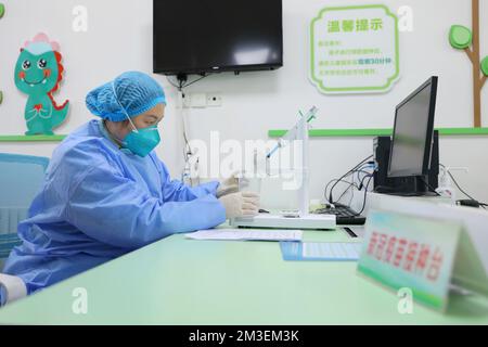 QINGDAO, CHINA - 15. DEZEMBER 2022 - Ein Mitarbeiter Injizierte inhalativen COVID-19-Impfstoff in einen zerstäubten Becher in einem gemeinnützigen Gesundheitszentrum in Qingdao, EAS Stockfoto