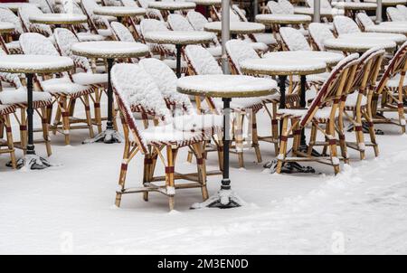 München, Deutschland. 15.. Dezember 2022. Schneebedeckte Stühle und Tische stehen vor einem Café in der Innenstadt. Kredit: Peter Kneffel/dpa/Alamy Live News Stockfoto