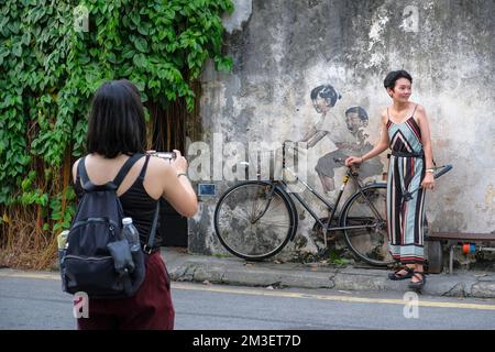 George Town, Malaysia - November 2022: Touristen machen Fotos mit einem Graffiti in George Town am 16. November 2022 in Penang, Malaysia. Stockfoto