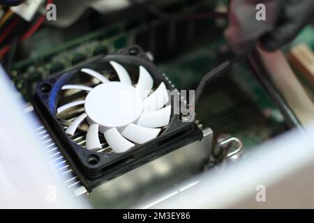 Entfernen des cpu-Kühlerlüfters aus dem alten Computer auf dem Tisch Stockfoto