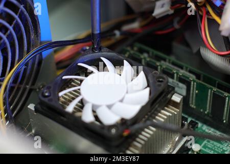 Entfernen des cpu-Kühlerlüfters aus dem alten Computer auf dem Tisch Stockfoto