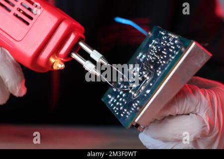 Lötkolben mit reda-Transformator auf dem Tisch durch Person Stockfoto