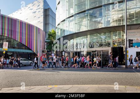 Shoppingtouristen und Besucher, die die Straße vor Debenhams und Costa Lord Street in Liverpool One überqueren Stockfoto