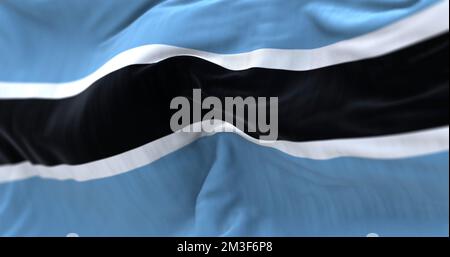 Nahaufnahme der im Wind wehenden Botswana-Nationalflagge. Die Republik Botswana ist ein Land im südlichen Afrika. Texturierter Hintergrund aus Stoff. Stockfoto