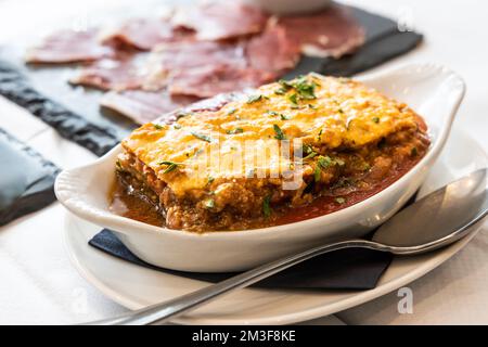 Serviert wird eine Portion köstlicher italienischer klassischer Rinderlasagne, serviert auf ovalem Teller Stockfoto