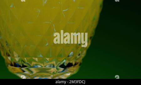 Grüner Hintergrund . Clip. Ein heller Hintergrund, auf dem gelbe kohlensäurehaltige Limonade in Gläser gegossen wird. Hochwertige 4K-Aufnahmen Stockfoto