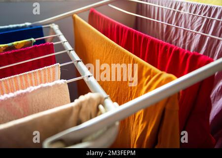 Nahaufnahme der gewaschenen, bunten Kleidung, die am Trockner hängt Stockfoto