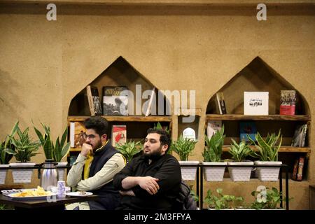 Teheran, Teheran, Iran. 14.. Dezember 2022. Die Iraner sehen am 14. Dezember 2022 im Nakhlestan Café in der Innenstadt von Teheran, Iran, eine Live-Übertragung des Halbfinalspiels der Katar-Weltmeisterschaft 2022 zwischen Marokko und Frankreich. Fans aus dem Iran, dem Libanon, dem Jemen, Syrien und Palästina versammeln sich im Nakhlestan Cafe, das vom Owj, der Arts and Media Organization des Islamic Revolutionary Guard Corps (IRGS), betrieben wird und sich im Besitz der Organisation für Kunst und Medien befindet, um die marokkanische Nationalmannschaft zu unterstützen. Nach dem Sieg gegen Portugal in Katar am 10.. Dezember trugen die Marokkaner palästinensische Flaggen, um ihre Unterstützung für die Palästinenser zu zeigen. Frankreich Ende Stockfoto