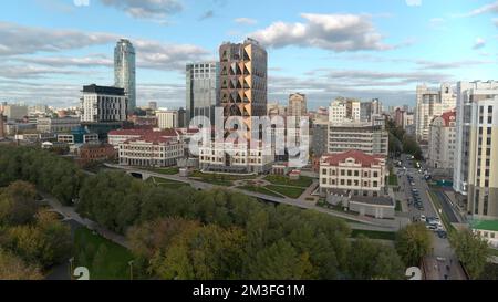 Luftaufnahme auf eine wunderschöne Stadt mit hohen Gebäuden und Grünflächen. Aktie-Aufnahmen. Konzept der Urbanisierung, Häuser auf bewölktem Himmelshintergrund Stockfoto