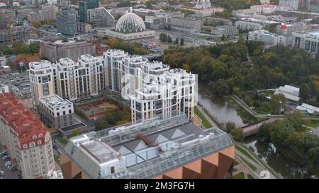 Wunderschöne Landschaft von einer Drohne. Aktienaufnahmen . Ein heller Blick auf die Bürogebäude im Stadtzentrum und einen wunderschönen Park mit einem Fluss w Stockfoto