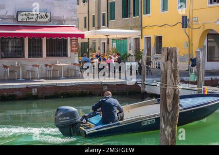 Italien Kanalrestaurant, Blick im Sommer auf eine Restaurantterrasse neben dem Canal Vena in Chioggia, Gemeinde Venedig, Italien Stockfoto