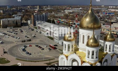 Luftaufnahme auf den Marktplatz und eine Kirche mit goldenen Kuppeln. Aktion. Sommerlandschaft mit Gebäuden und Häusern Stockfoto