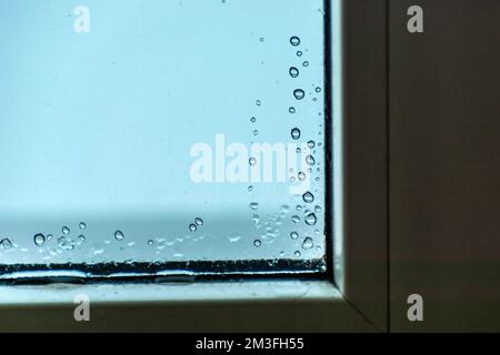 Wassertropfen auf dem Glas in der Ecke des Fensters, Winterblick Stockfoto