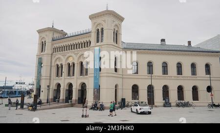 Italien, Mailand - 7. Juli 2022: Wunderschönes Konzerthaus an einem bewölkten Tag. Aktion. Architekturkonzept, Straße mit Menschen und geparktes Auto Stockfoto