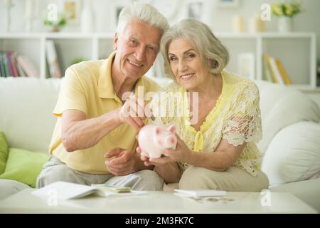 Glückliche Familie. Alte Senioren mit Piggybank Stockfoto