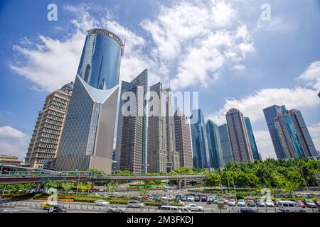 Reihen von hohen Gebäuden und urbanen Wäldern in Lujiazui, Pudong, Shanghai, China im Sommer mit blauem Himmel und Wolkenhintergrund Stockfoto