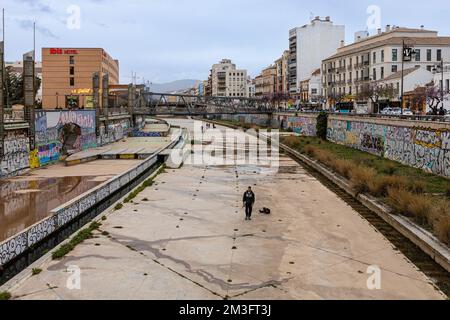 Der Fluss Guadalmedina, der die Stadt Malaga in zwei Hälften teilt, und die Brücke Puente de La Trinidad im Hintergrund. Malaga, Andalusien, Spanien. Stockfoto