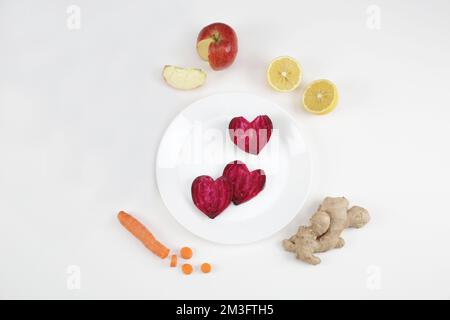 Rote-Bete-Karotte-Zitronen-Ingwer auf Holzbrett Stockfoto